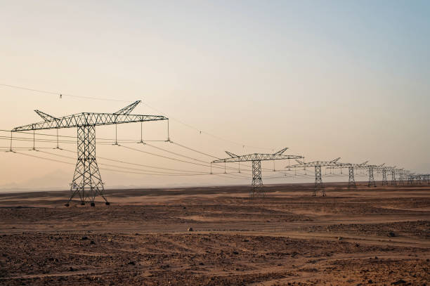 istock Electricity pylons in sand desert 1260197958