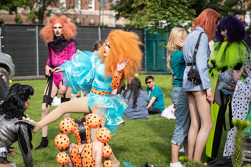 Drag artists talking and fooling around back stage at the Dublin Pride festival 2019, in bright costumes and big hair
