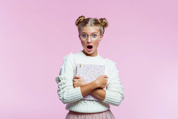 istock Surprised teenege girl holding pink diary 1260227883