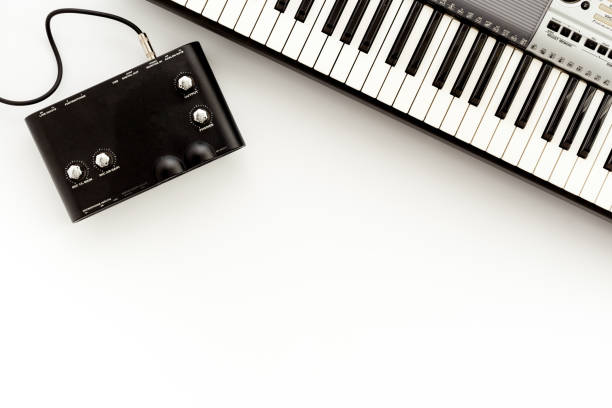 Musician work set with synthesizer, note and headphones Yellow table background top view space for text