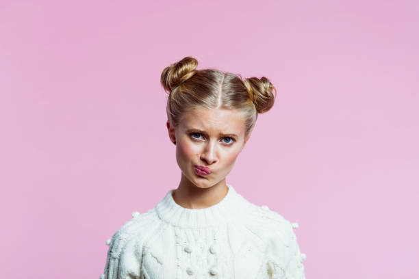 teenege chica grimacing - decisions teenage girls horizontal studio shot fotografías e imágenes de stock