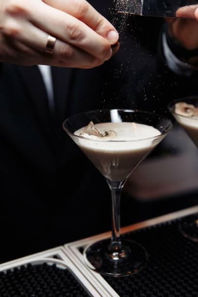 istock hands of a bartender holding a shaker pouring a drink into a martini glass 1260231884