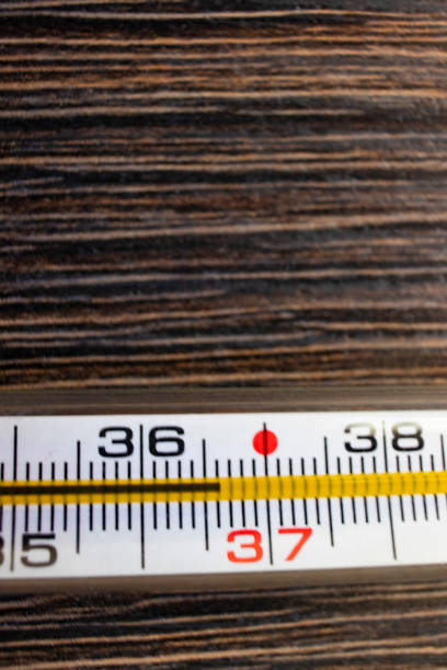 istock Temperature 36.6 on a thermometer on a wooden background at home 1260234857