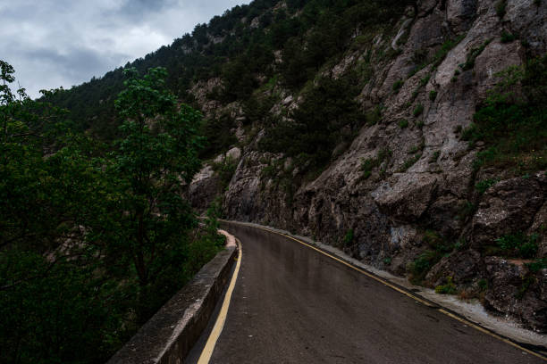 istock Asphalt road through the mountains forest in rainy season 1260238090