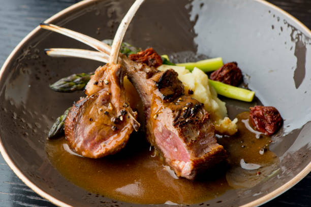 costeletas de cordeiro ou rack de cordeiro. grama grau a alimentada com bifes de carne angus. tenderloin, filé mignon, tira de nova york, osso em olho de costela grelhado para meio perfeito raro na grelha a lenha ao ar livre. clássico americano entrada c - rack of lamb - fotografias e filmes do acervo