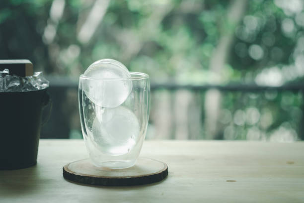 Round ice in double wall glass on wood table