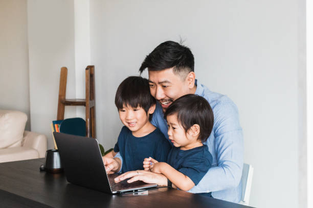 istock Two brothers play video game on laptop with their dad 1260272922