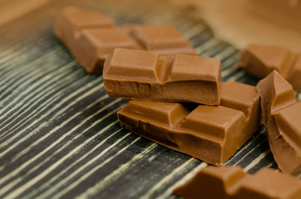 istock Milk chocolate bar. Chocolate over rustic wooden background. 1260277249
