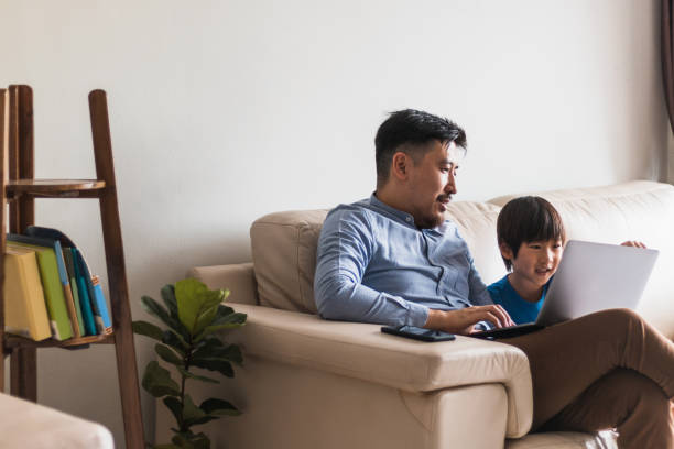 istock Happy boy and his dad watching something on laptop together 1260278500