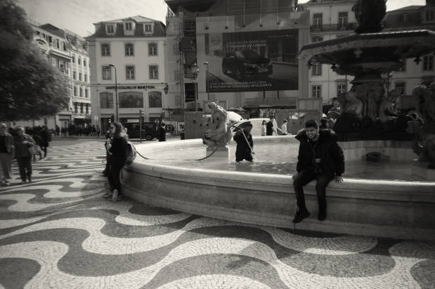 Lisbon, Portugal - February 28, 2019: A worker cleans a fountain in the Rossio Square in Lisbon downtown.