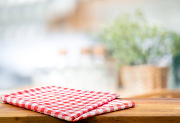 istock Red fabric,cloth on wood table top on blur kitchen counter (room)background 1260298416