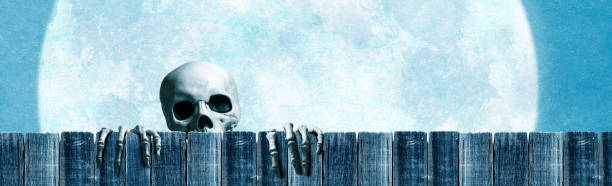 istock Skeleton Peering Over A fence In Front Of Large Full Moon 1260313034