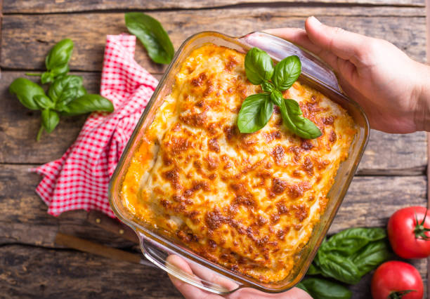 istock Traditional italian lasagna with vegetables, basil, minced beef meat, tomato and cheese on wooden  background. 1260320892