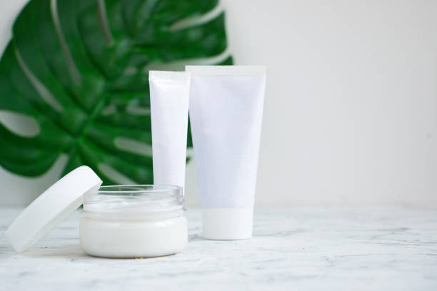 istock Empty white tubes for cosmetic products lie on a light concrete background. Creative layout copy space for text. 1260322435
