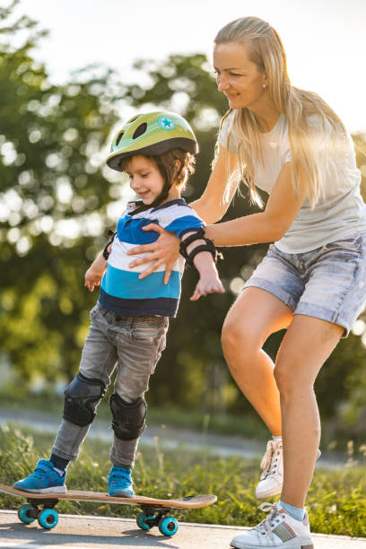 istock Mom helps a son to drive a skateboard 1260322441