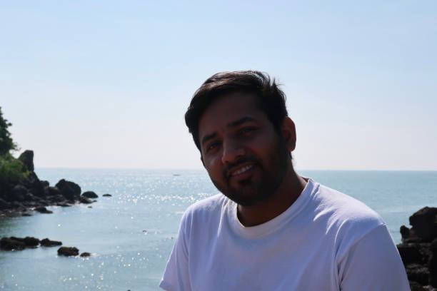 istock Image of Indian man outdoors in posing while looking at camera stood in front of sea view 1260327433