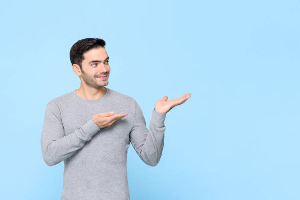istock Young handsome Caucasian man with hands opening to copy space aside 1260357674