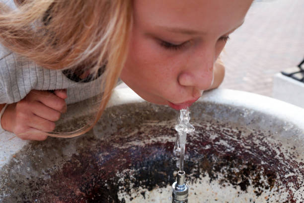 istock girl drinks water from a fountain close up 1260365340