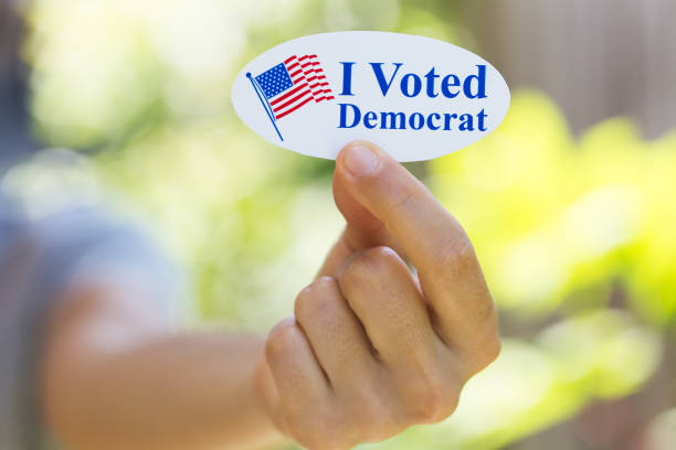 istock Hand holding I voted Democrat sticker 1260366929