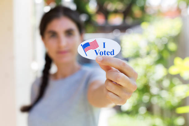 istock Young woman holding I voted sticker 1260367496