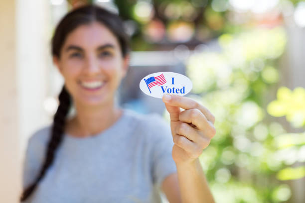 istock Young woman holding I voted sticker 1260369098