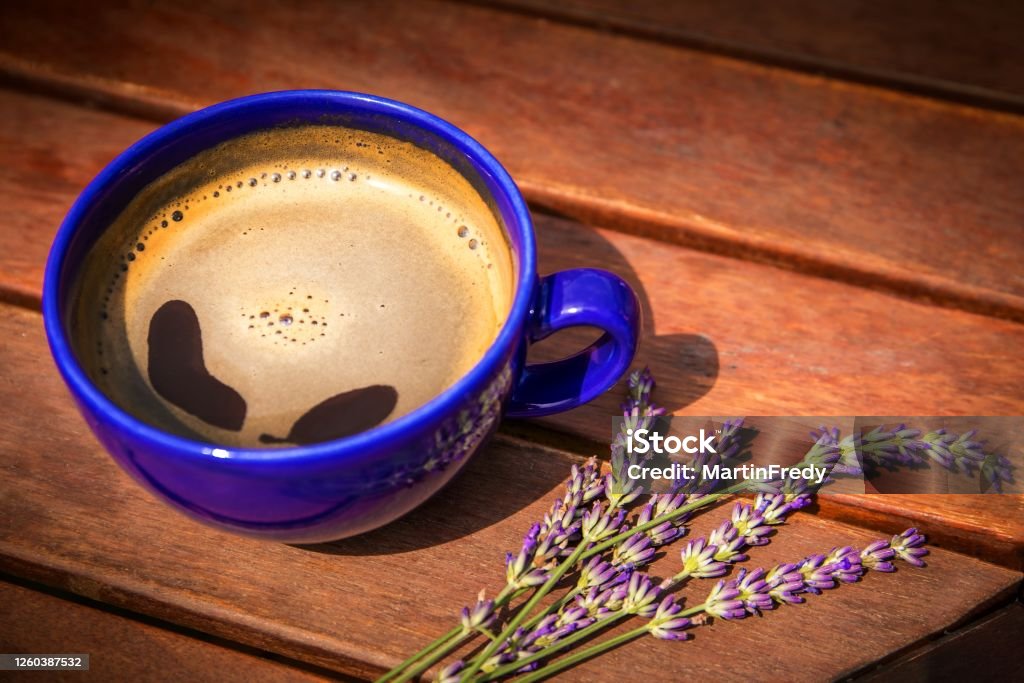 Cup of hot coffee and lavender on a wooden table. Aroma of coffee and lavender. Romantic morning. Latte Stock Photo