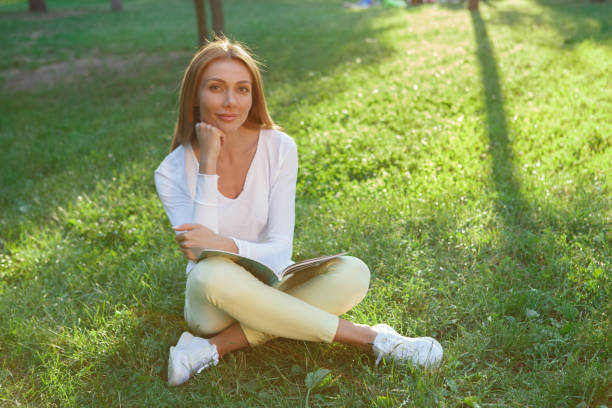 istock Beautiful woman at the park with a book 1260422816