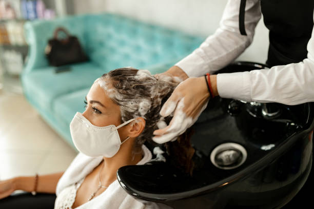 счастливая женщина в защитной маске для лица во время мытья волос у парикмахера. - men human hair washing hairdresser стоковые фото и изображения