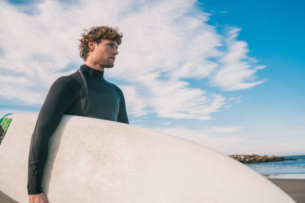 istock Surfer standing in the ocean with his surfboard. 1260445783