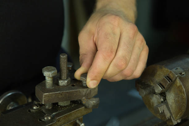 istock Working on a lathe. Preparing and setting up the machine. Hands of the master. 1260447927