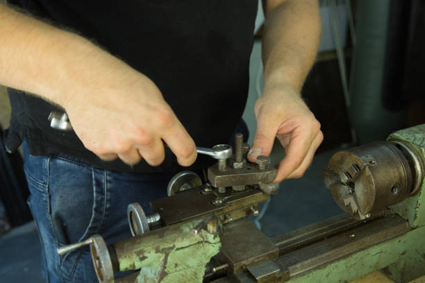 istock Working on a lathe. Preparing and setting up the machine. Hands of the master. 1260449031