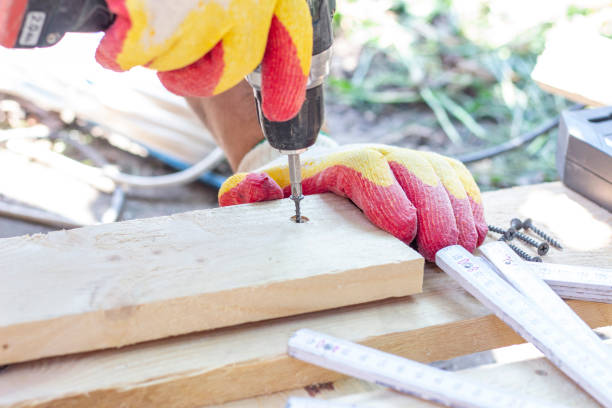 istock screwdriver. a specialist drives a screw into a wooden surface 1260473988