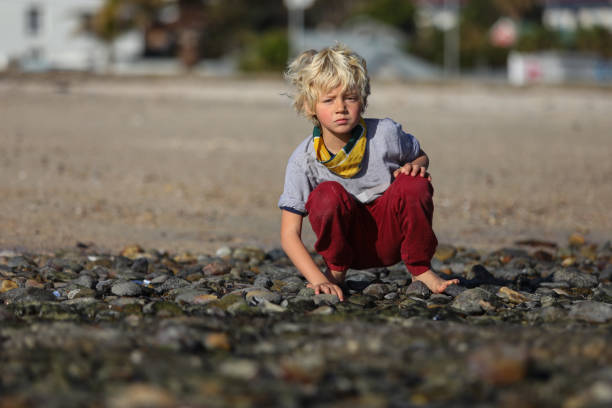 istock A young boy searching for treasure on a beach. 1260488213