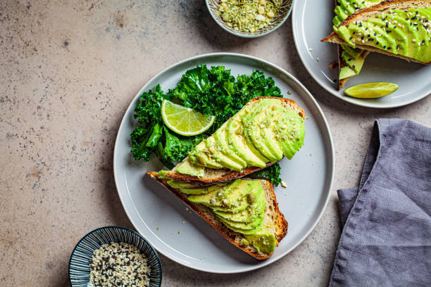 avocado toasts with seeds on a gray plate, top view, copy space. plant based diet concept. - food vegan food gourmet vegetarian food imagens e fotografias de stock