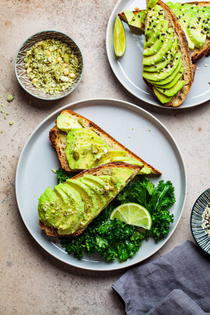 avocado toasts with seeds on a gray plate, top view. plant based diet concept. - food vegan food gourmet vegetarian food imagens e fotografias de stock