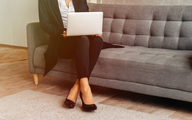 istock Closeup of woman using laptop computer, sitting on the sofa 1260506219