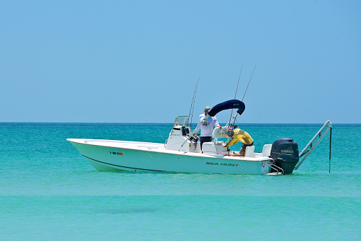 Holmes Beach, Anna Maria Island FL / USA - May 1, 2018: People Fishing from a Power Boat in the Gulf of Mexico