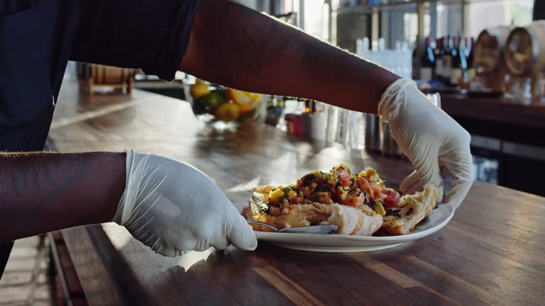 Gloved Server Placing Ceviche on Table