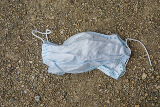 istock A used surgical face mask on the ground 1260540103