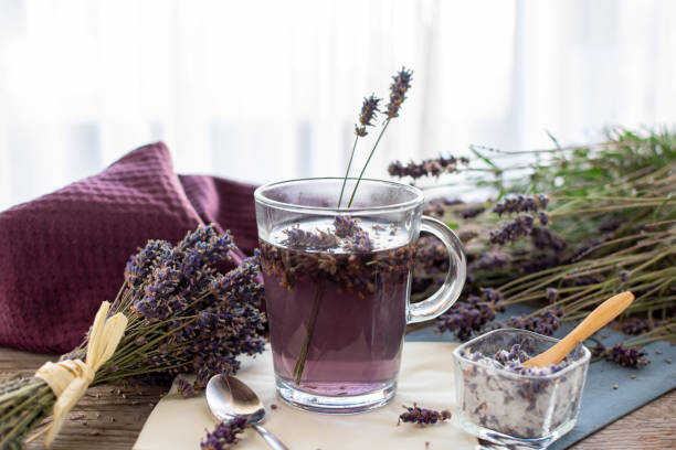 Lavender tea rustic on wood in a glass teacup. Lavender tea rustic on wood in a glass teacup. Lavender (Lavandula angustifolia), has a calming and antispasmodic effect. anti inflammatory stock pictures, royalty-free photos & images