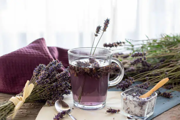 Lavender tea rustic on wood in a glass teacup. Lavender (Lavandula angustifolia), has a calming and antispasmodic effect.