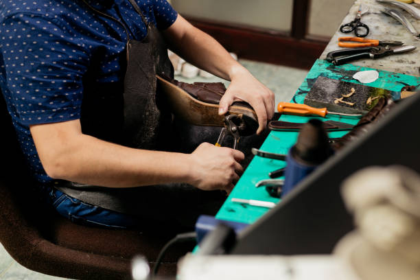 istock Cobbler repairing shoe 1260554528
