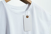 White t-shirt with blank price tag on wooden hanger