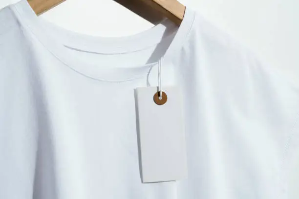 White t-shirt with blank white price tag mockup, template on wooden hanger