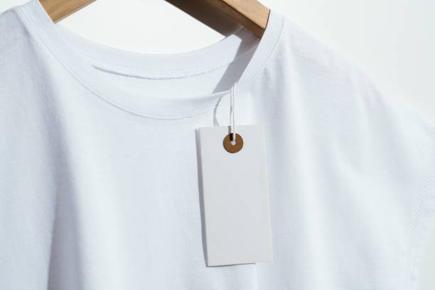 white t-shirt with blank price tag on wooden hanger - white clothing imagens e fotografias de stock