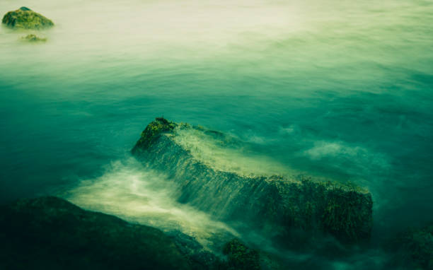 岩の上の揺れる波の柔らかい禅のような海景 - zen like sea horizon over water blurred motion ストックフォトと画像