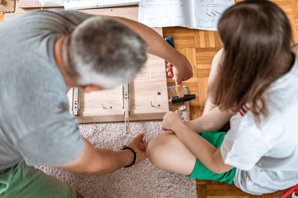 istock Father and daughter assembling a new furniture 1260587895