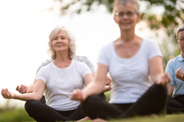 istock Seniors meditate in group outdoors 1260600293