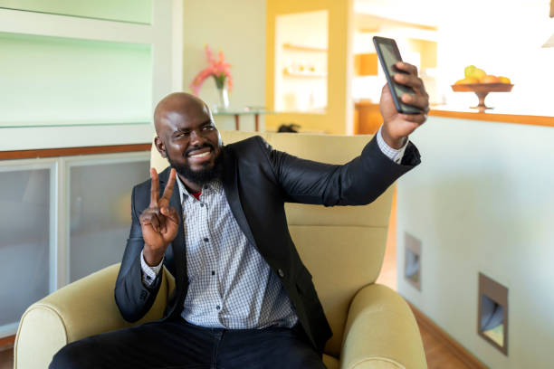 istock Smiling man in the living room is taking a selfie 1260648313