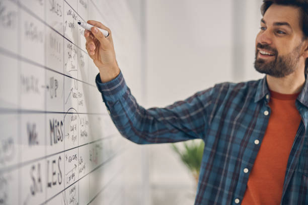 istock Handsome male worker writing on whiteboard in office 1260696112